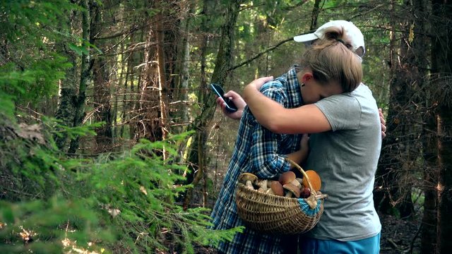 Man hug sad woman because of loss in forest when picking mushrooms