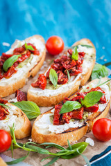 Bruschetta with cream cheese, pesto, fresh basil and sun dried t