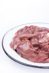 Raw chicken liver in the metal plate over white background