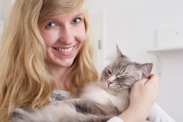 young woman stroking ragdoll cat