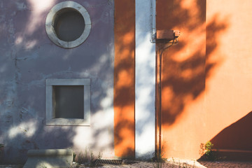 light and colors wall in a summer day, shadows tree on buildings