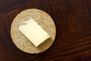 Single Scottish oatcake with a slice of yellow cheese.