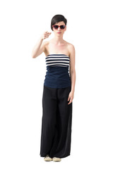 Young trendy short hair woman wearing sunglasses pointing finger at camera. Full body length portrait isolated over white studio background.