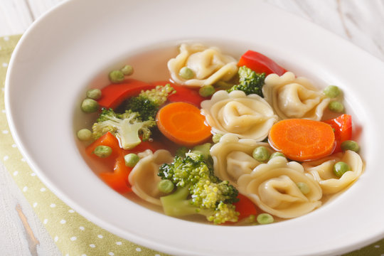 Italian soup with tortellini and vegetables closeup at the plate. horizontal
