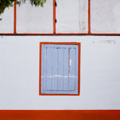 Old window with blue shutters on white