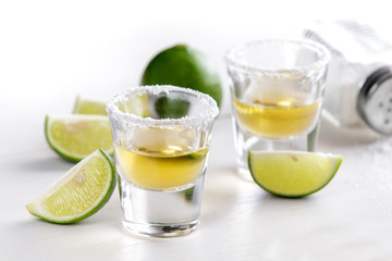 two tequila shots with lime slice and salt