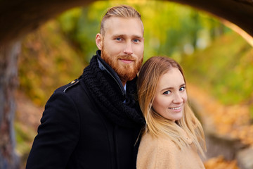 Redhead bearded male hugs the cute blonde female.