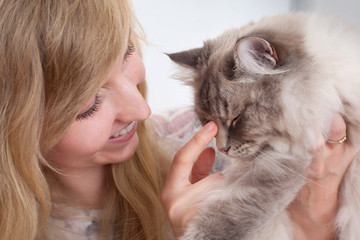 young woman nudging ragdoll cat nose