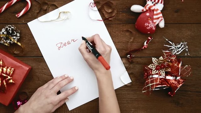 Young Woman Sitting At Wooden Table Writing Letter To Santa At Christmas Holiday. Concept Of New Year Magic, Dream And Tradition.