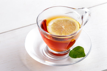 a cup of hot lemon tea with lemon slice and lemon leaf