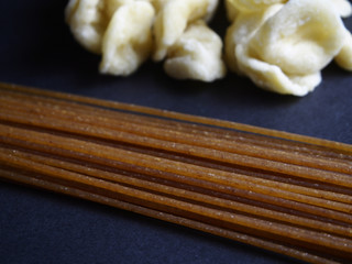 Wholegrain and natural fresh pasta on black background