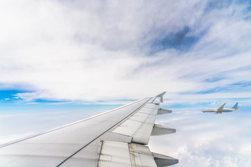 plane flying through cloud with wing of aeroplane foreground.