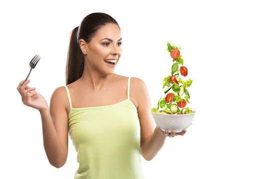 Beautiful, fit young woman holding a bowl of salad