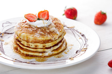 Obraz na płótnie Canvas homemade pancake with honey and strawberry topping