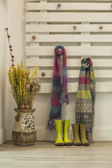 Green boots and colorful scarfs hanging in a pallet wall