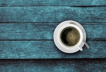 Cup of coffee on a grunge blue wooden table.Empty ready for your