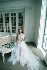 Young women with wedding dress in very bright room, some fine fi