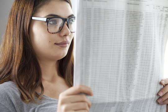 Young woman reading newspaper