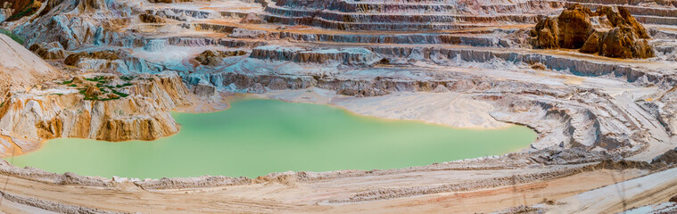 Abandoned kaolin quarry with white plaster material and lake