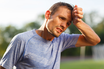 Tired exercise and heat sporty man wiping sweat from face