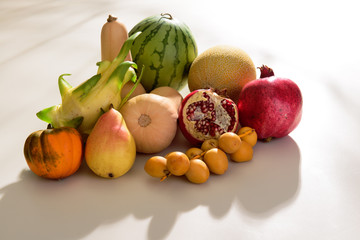 collection of tropical fruits on the white table including mini water melon, mini melon, mini pumpckin