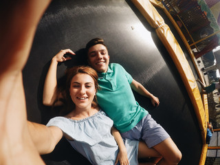 Couple lie on trampoline in the park