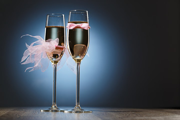 Champagne glasses with pink grooms bow-tie and brides veil