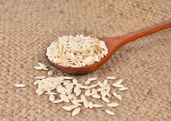 cucumber seeds in wooden spoon on hemp sack background