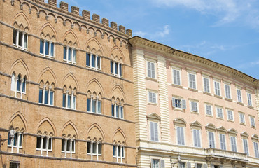 Facade of a historic buildings with its windows on the square of Siena, Italy.