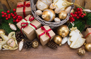 Christmas or New Year background: fur-tree, branches, gifts, colored glass balls, decoration and cones on wooden background