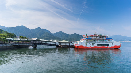 Fototapeta premium Pasażerowie wysiadają z promu w Terminalu Promowym Miyajima na wyspie Miyajima, Hiroszima, Japonia