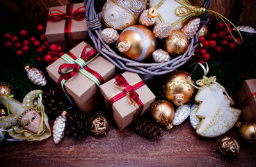 Christmas or New Year background: fur-tree, branches, gifts, colored glass balls, decoration and cones on wooden background
