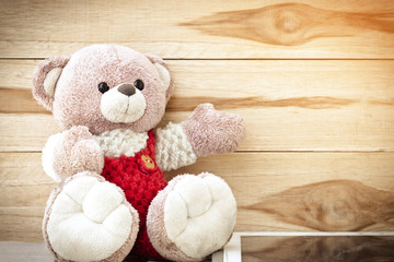 Cute Teddy Bear With Tablet on wood background