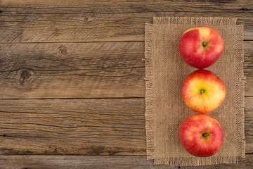Red apples on the old wooden table.