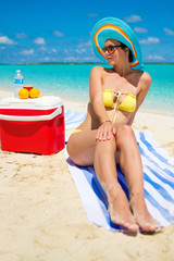 Woman in bikini sunbathing on the beach in Exuma, Bahamas
