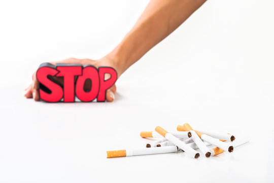 Stop smoking concept, bunch of cigarettes on white background with sign stop