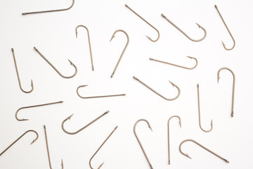 Many fishing hooks on a white paper background