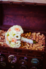 White and pink wedding bouquet lies in the wooden chest