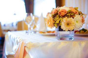 Bouquet made of autumn flowers stands in the cube vase