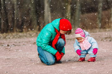 mother and little daughter playing outdoors in winter