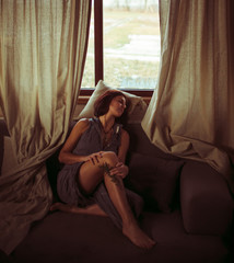 Obraz premium Girl relaxing near the window