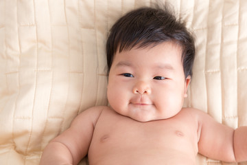 Adorable baby girl lying in the bed.