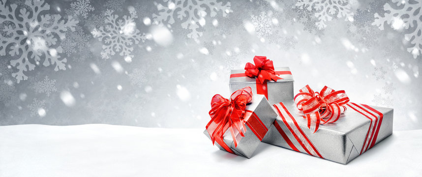 Weihnachtsgeschenke in Rot und Silber auf Schnee Hintergrund
