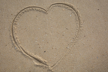 Heart drawn in the sand. Beach background. Top view