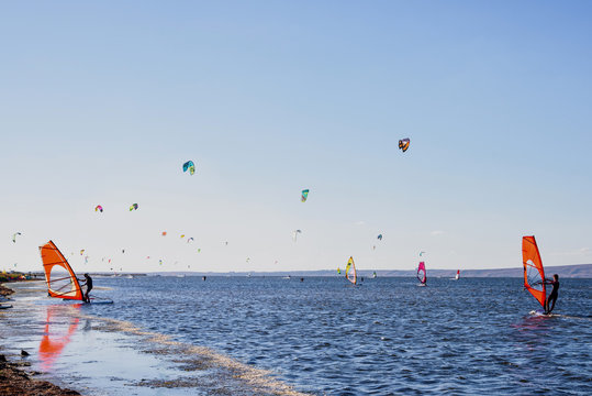 Windsurfers on a sand beach, young woman to take serfing training of from a coach. Blaga beach, Russia, Blagoveshensk