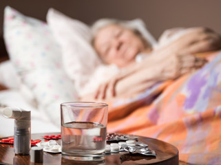 Obraz na płótnie Canvas Sick old woman lying at bed bed