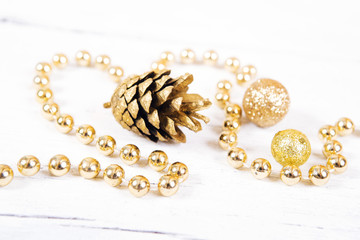  Brilliant gold  cones like christmas decoration. Yellow cones and balls  isolated on white wooden background.