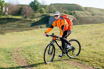 Fototapeta premium Young man standing with bicycle on an countryside