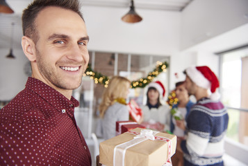 Young man standing in front of camera with Christmas presents