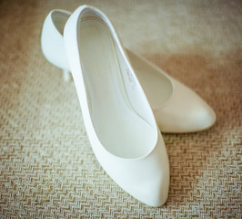 Classy white shoes stand on the beige carpet